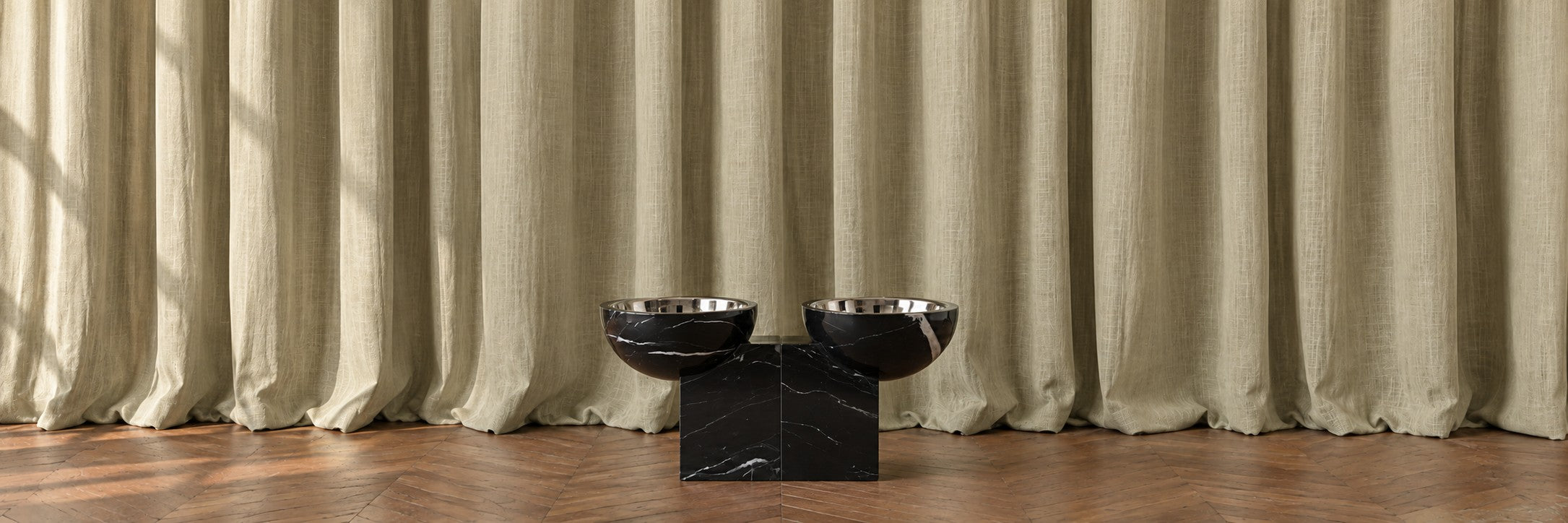 Marble pedestal bowl in front of draped fabric
